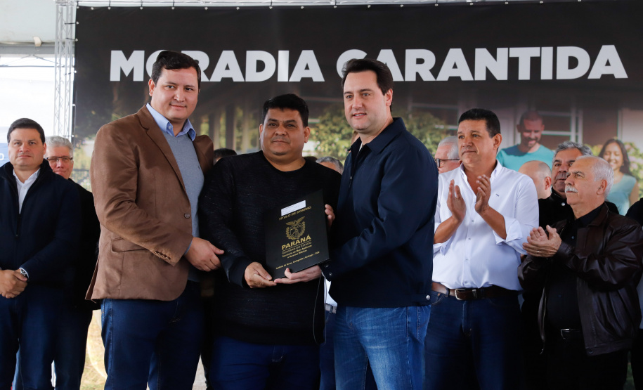 O governador Carlos Massa Ratinho Junior entregou nesta quinta-feira (15) os títulos de propriedades de imóveis para 367 famílias de Paranaguá, no Litoral. Elas ocupam terras devolutas, pertencentes ao Estado. A titulação corresponde a uma área de aproximadamente 112 hectares, abrangendo as localidades de Jardim Jacarandá e Ouro Fino, no perímetro urbano de Paranaguá.