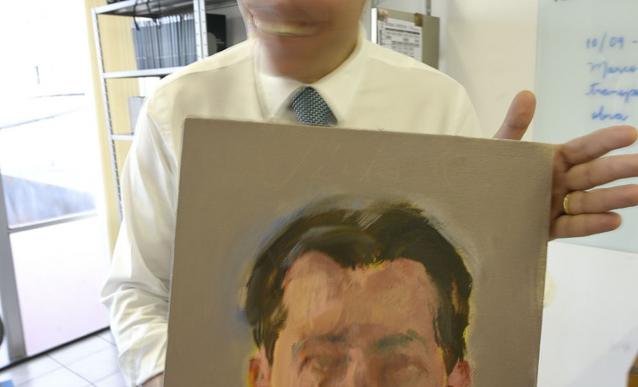 O chinês Tong Yanrunan trabalha com retratos "face a face". Na foto, o diretor do MCAA com obra pintada pelo artista.Foto: Kraw Penas/SECC