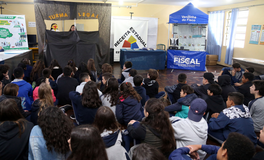 É de pequenino que se torce o pepino. A frase é um chavão e os alunos nem são tão crianças assim. Com idades entre 11 e 12 anos, cerca de 400 alunos da Escola Estadual Nossa Senhora da Salete, de Curitiba, aprenderam de forma lúdica sobre a função social dos impostos e por que eles são importantes no exercício da cidadania..Foto Gilson Abreu/AEN