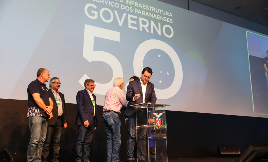 O Governo do Paraná lançou um grande pacote de habitação popular que prevê a construção de 9 mil moradias em diversos municípios do Estado até 2022. O investimento é da ordem de R$ 1 bilhão a serem aplicados ao longo dos próximos três anos. O protocolo de intenções firmado com a Pacaembu Construtora foi assinado pelo governador Carlos Massa Ratinho Junior nesta quinta-feira (31), durante a abertura do evento Governo 5.0, em Foz do Iguaçu.  Foto: Geraldo Bubniak/AEN