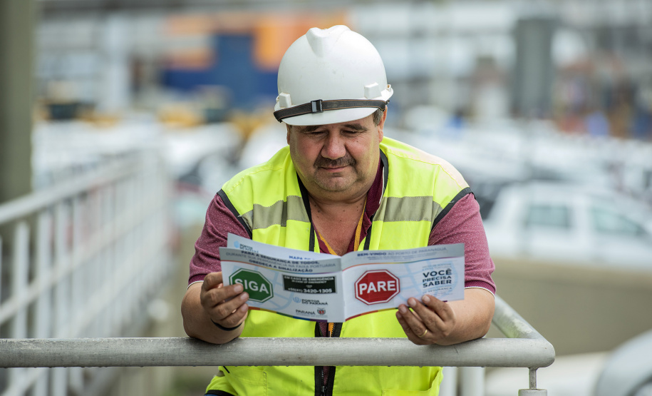 A partir desta semana, os trabalhadores que entram no cais público do Porto de Paranaguá recebem informações claras sobre as regras gerais de segurança e o regulamento da rota de tráfego de veículos e pedestres. Além de banners e cartazes, são entregues cartilhas com orientações de velocidade, equipamentos e práticas para tornar o ambiente portuário mais seguro. O conteúdo também está disponível no site da Portos do Paraná (www.portosdoparana.pr.gov.br).