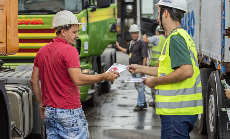 A partir desta semana, os trabalhadores que entram no cais público do Porto de Paranaguá recebem informações claras sobre as regras gerais de segurança e o regulamento da rota de tráfego de veículos e pedestres. Além de banners e cartazes, são entregues cartilhas com orientações de velocidade, equipamentos e práticas para tornar o ambiente portuário mais seguro. O conteúdo também está disponível no site da Portos do Paraná (www.portosdoparana.pr.gov.br).