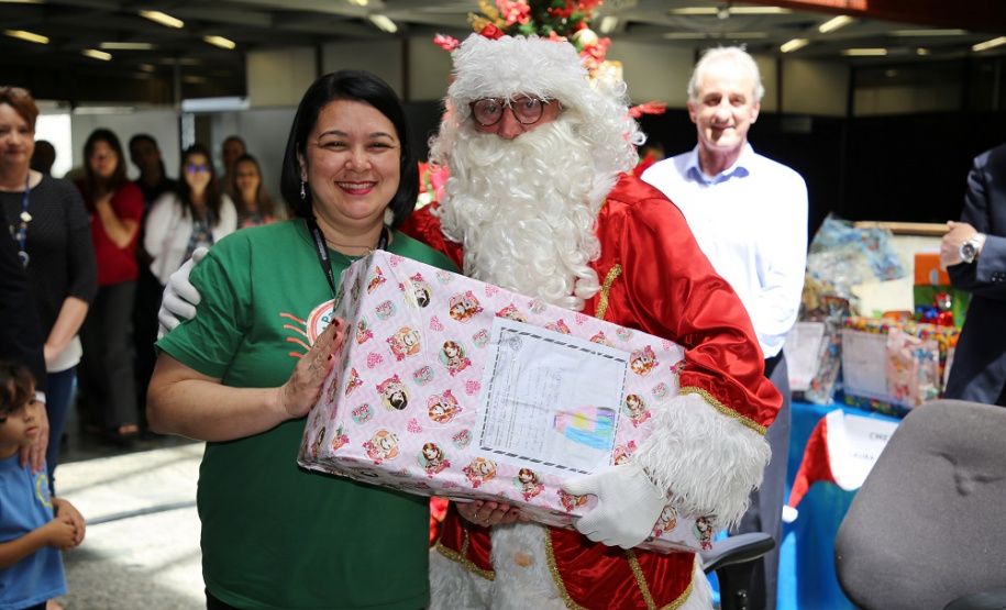 Alessandra recebe do Papai Noel presente que simboliza doações. Foto: Sanepar