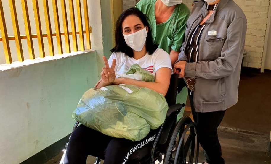 Quem se emociona por poder voltar para casa recuperada, depois de 20 dias de internamento por causa da Covid-19, é a dona de casa Lillian Marques Gontijo, de 33 anos. Ela recebeu alta do Hospital Universitário de Londrina, no Norte do Estado, na quinta-feira (9), com direito a comemoração por parte da equipe que cuidou dela no HU. 
.Foto: Divulgação/SESA