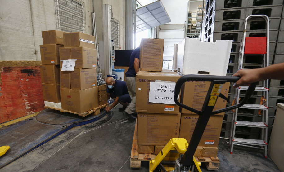 A Secretaria da Saúde do Paraná vai dar início neste sábado (16) à distribuição da primeira remessa de insumos destinados à vacinação da Covid-19 no Estado. Quatro caminhões vão sair pela manhã da central de abastecimento e suprimentos da secretaria, no Jardim Botânico, em Curitiba, carregados com 2,2 milhões de itens que serão entregues a 20 Regionais de Saúde do Estado. 
 Foto:Jonathan Campos/AEN